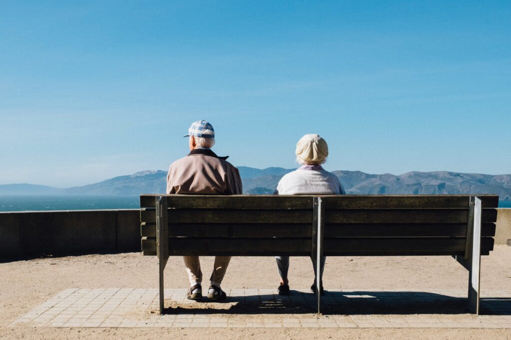 two adults sitting on a bench looking out